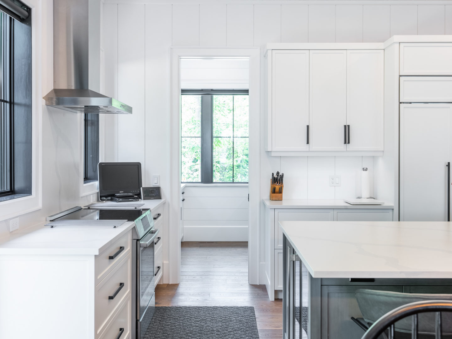 A modern kitchen with white cupboards and countertops.