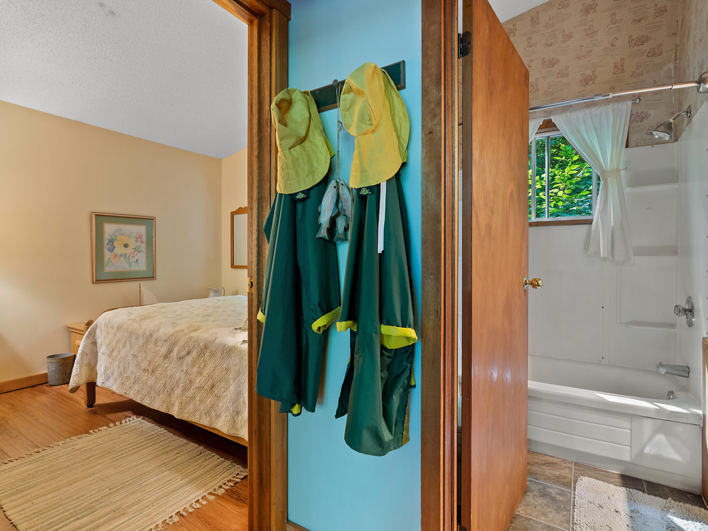 A hallway space with two open doorways, one leading into a bedroom and one leading into a bathroom.