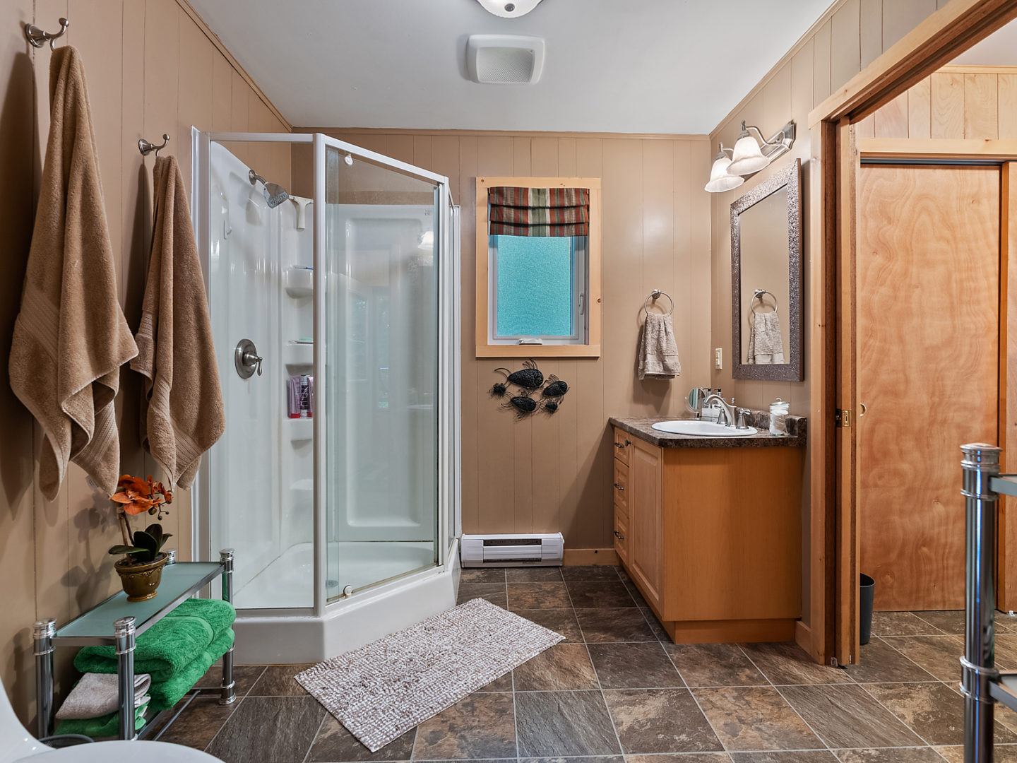 A large ensuite bathroom with a walk-in shower and a sink beside it.