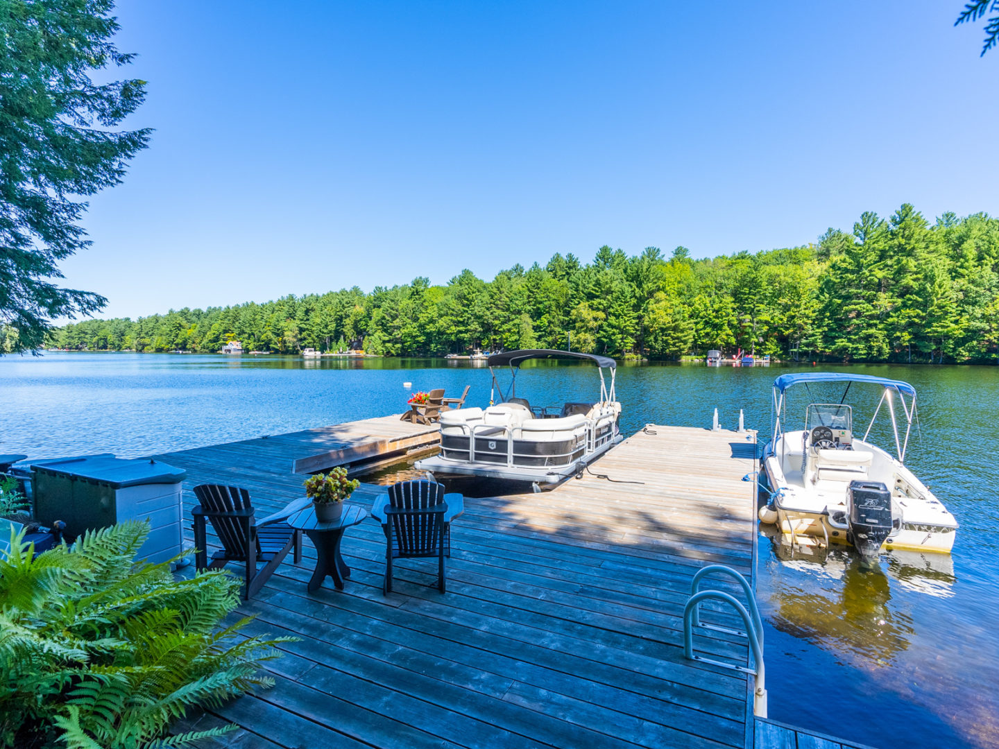View from a dock, looking out across a blue lake.
