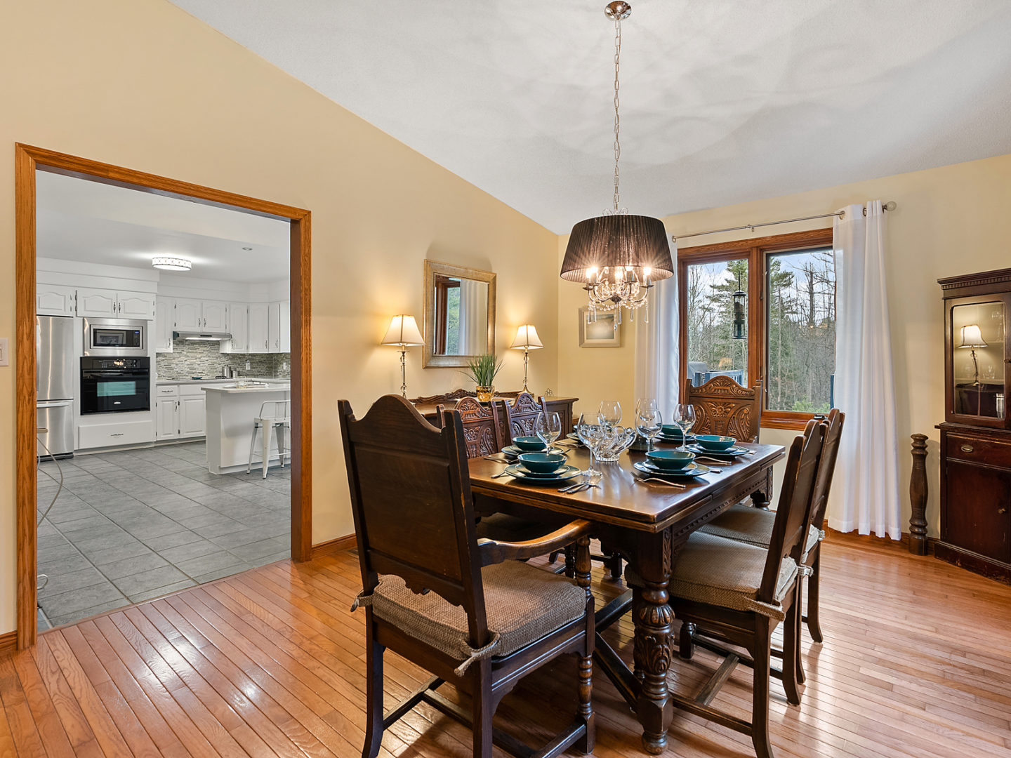 A modest dining area with a table and chairs, leading through a doorway into a kitchen.