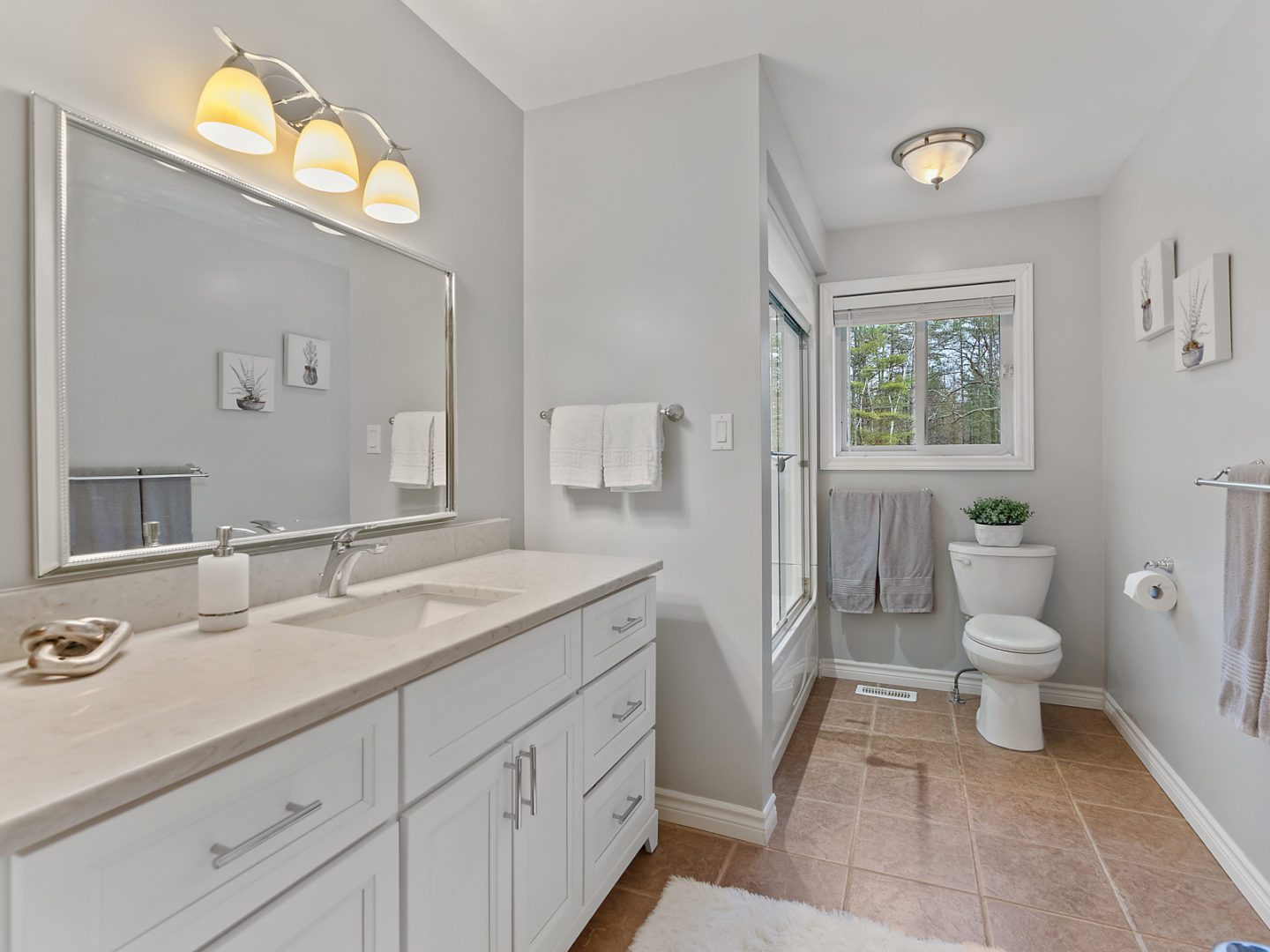 A large bathroom with a toilet, a sink, and a bathtub/shower combo.