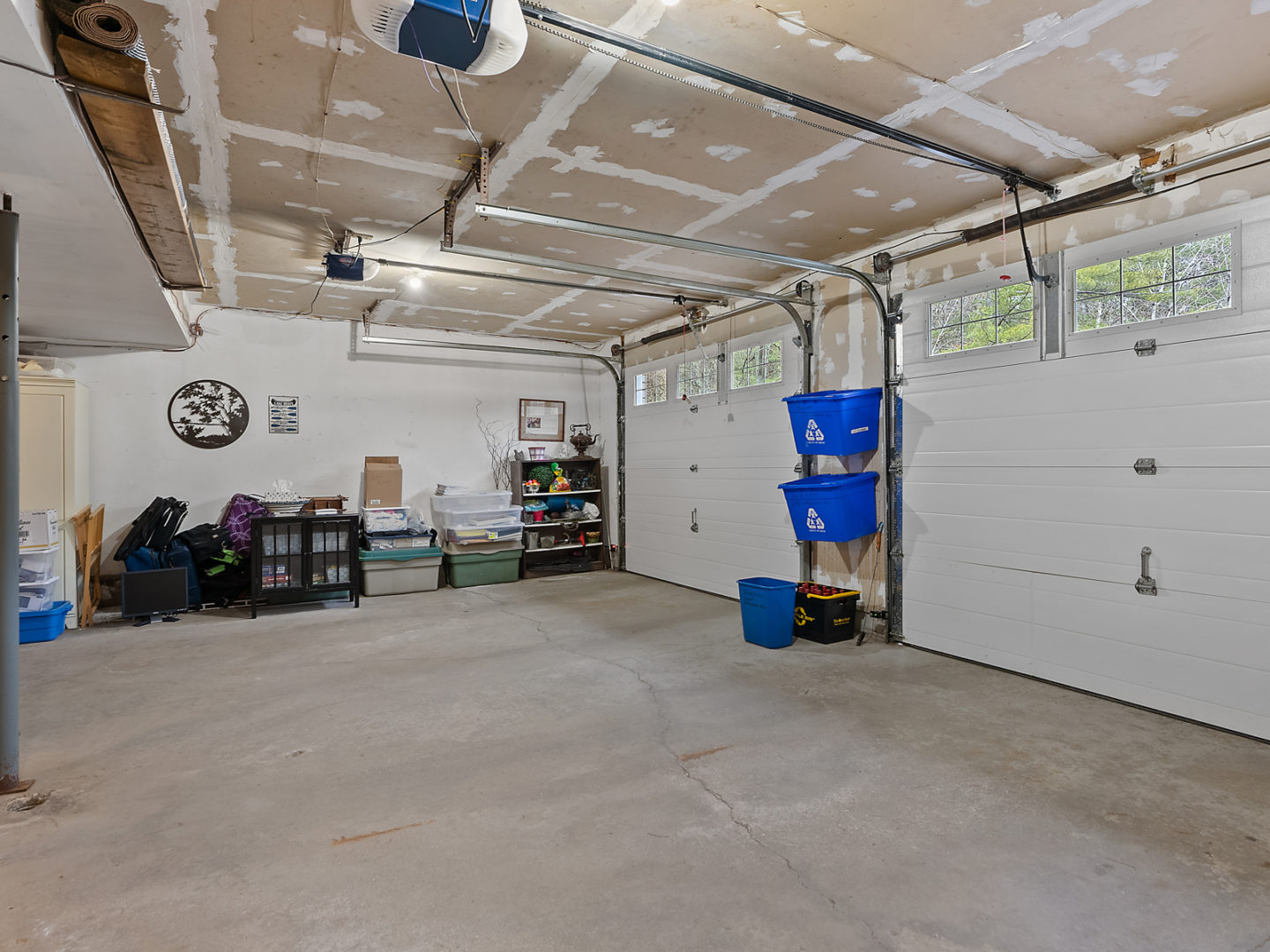 A large double garage space with an unfinished ceiling.