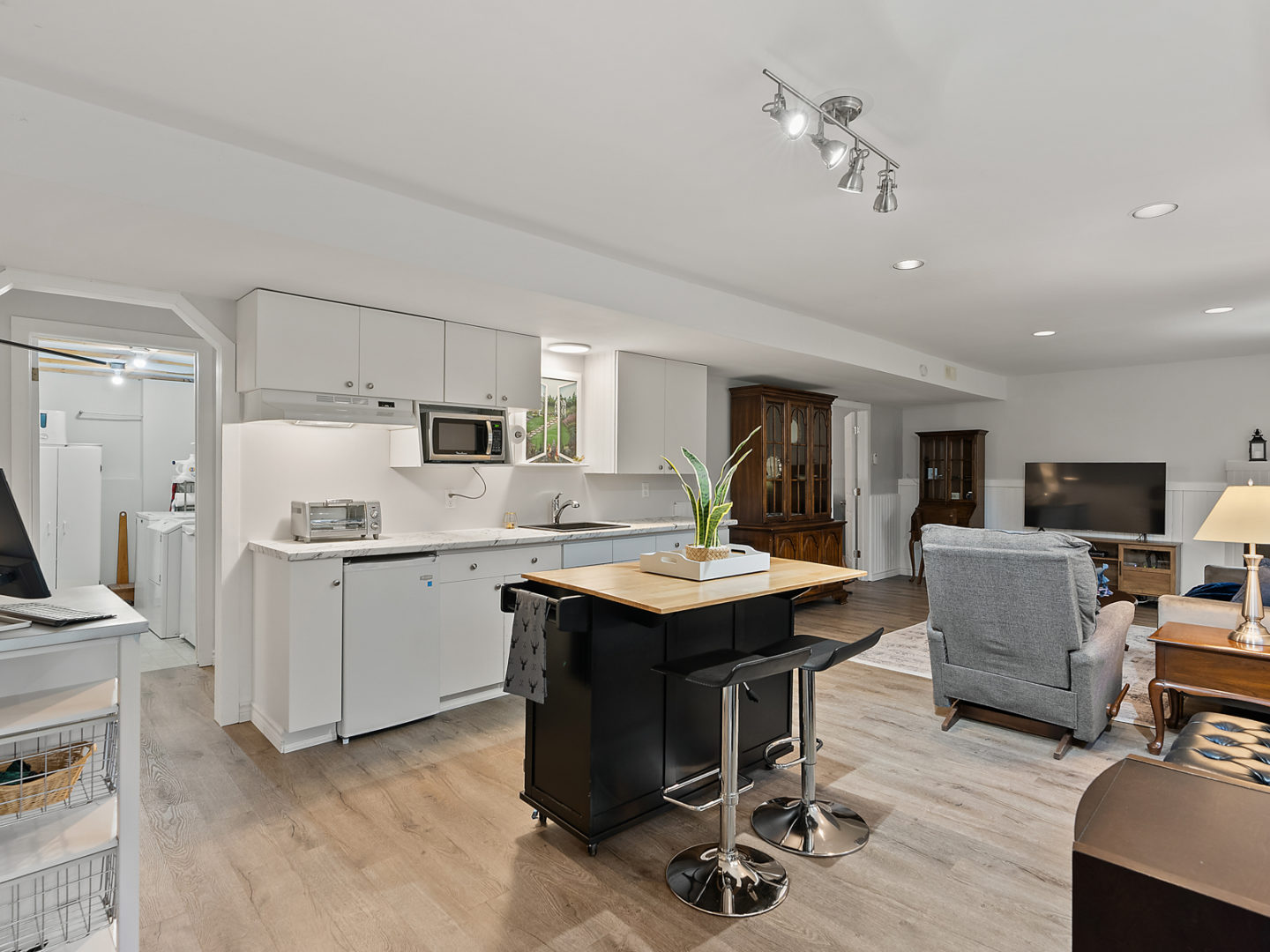 A large open-concept space with a small kitchen area and a living room.