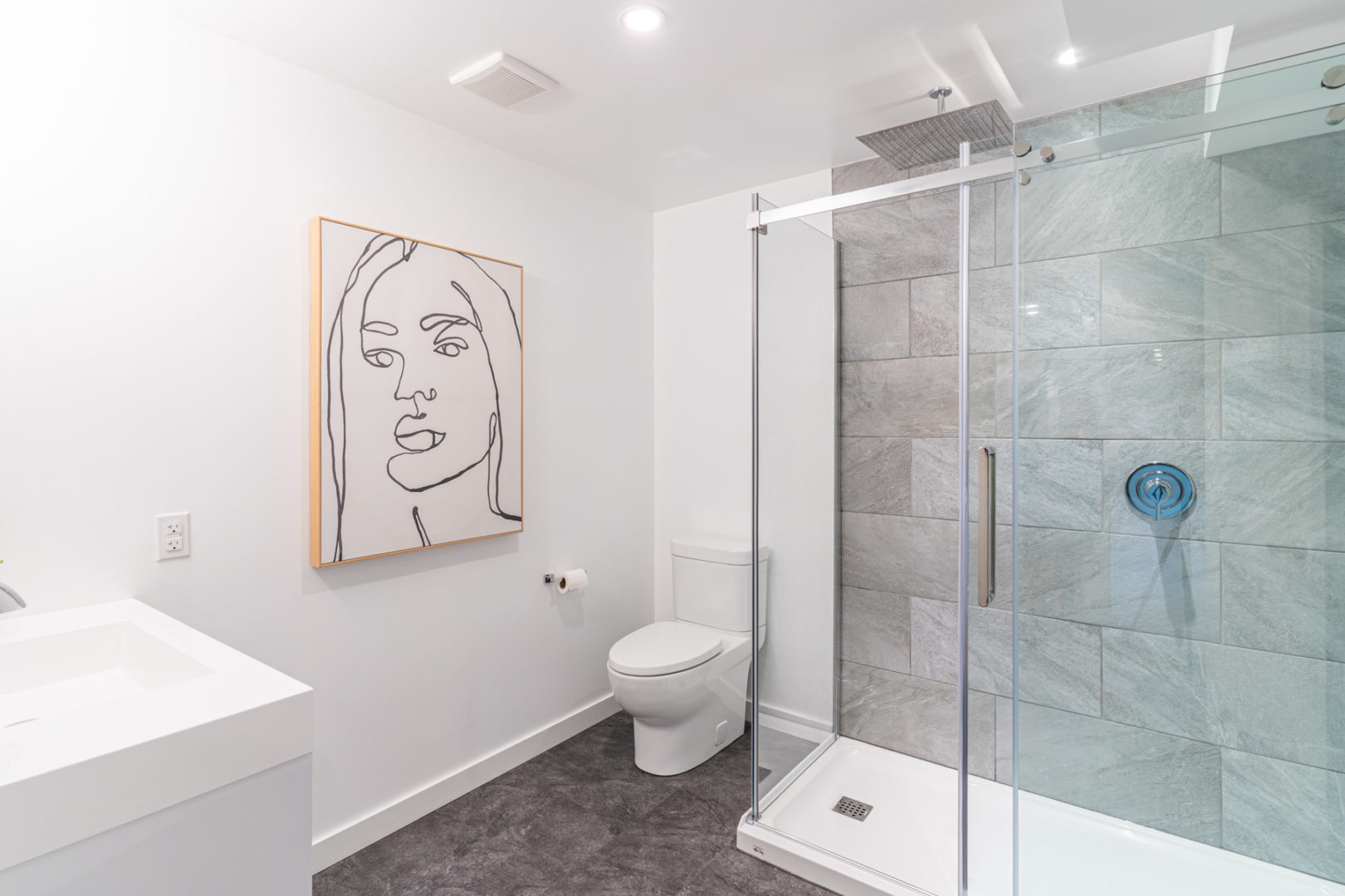 A big bathroom with a toilet, a sink, and a walk-in shower.