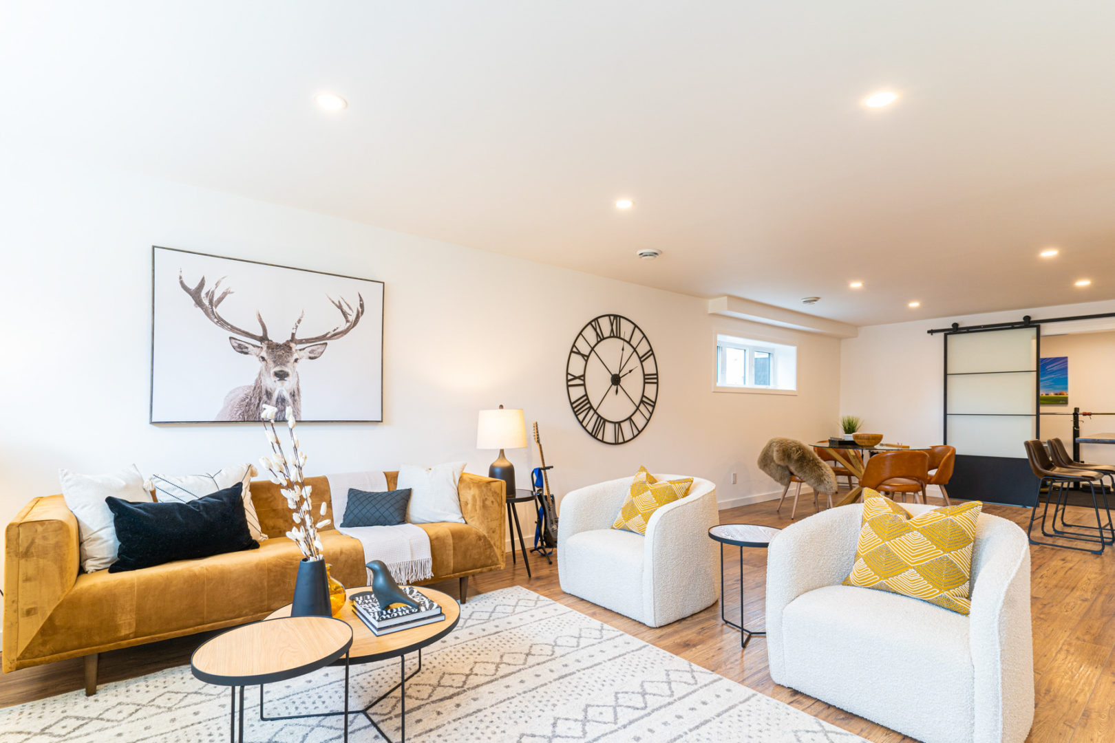 A basement living room area with two chairs, a couch, and a coffee table.