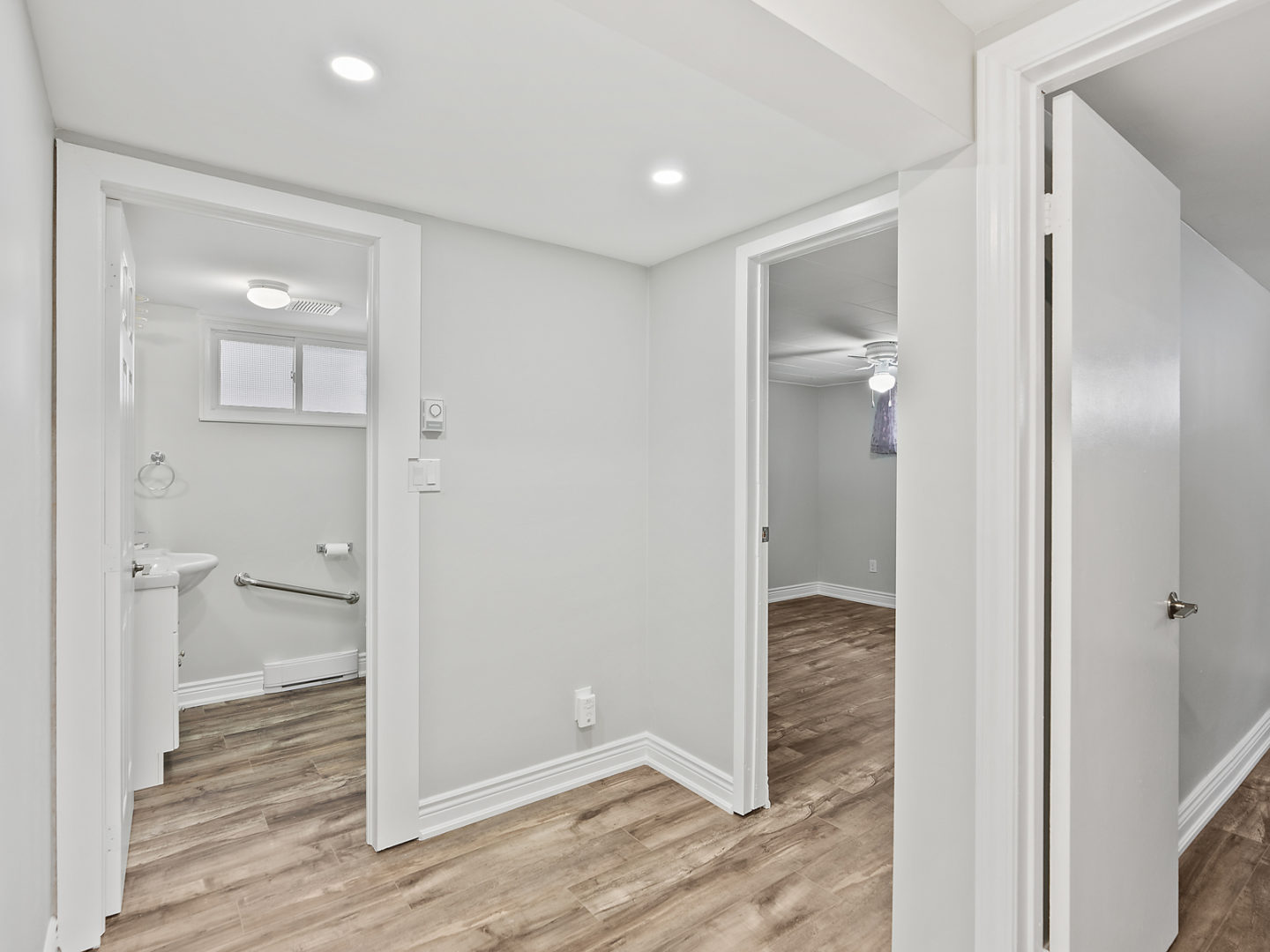 A small corner of a downstairs area with doorways leading into a bathroom and a bedroom.