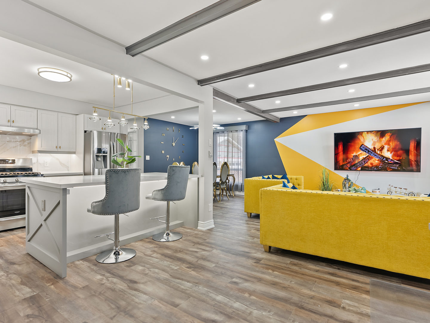 A bright, newly renovated living area with an open-concept space allowing flow between a kitchen, dining area, and a living area.