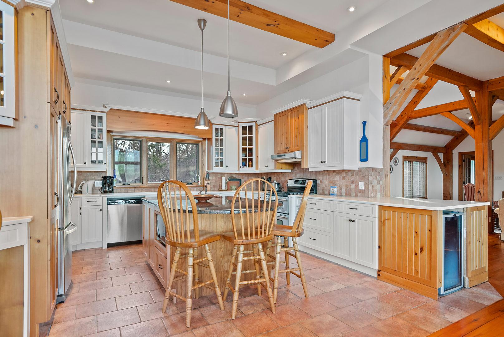 A small kitchen with white cupboards, an island, and updated appliances.