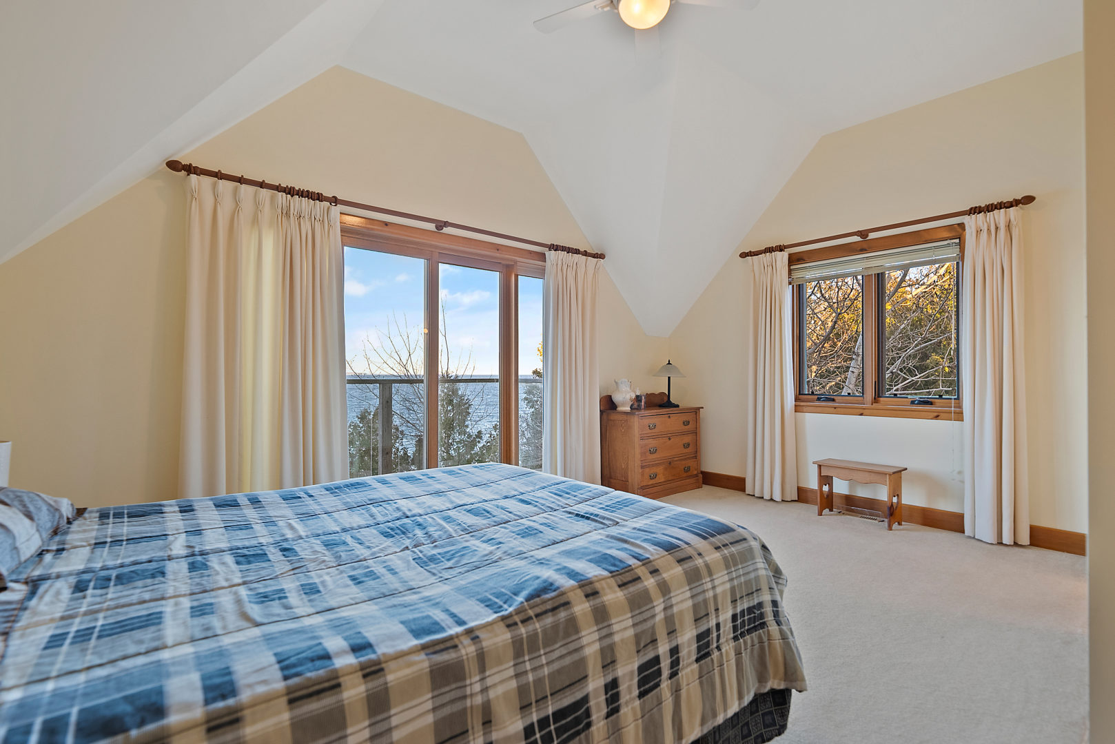 A bright bedroom with a double bed and a large window.