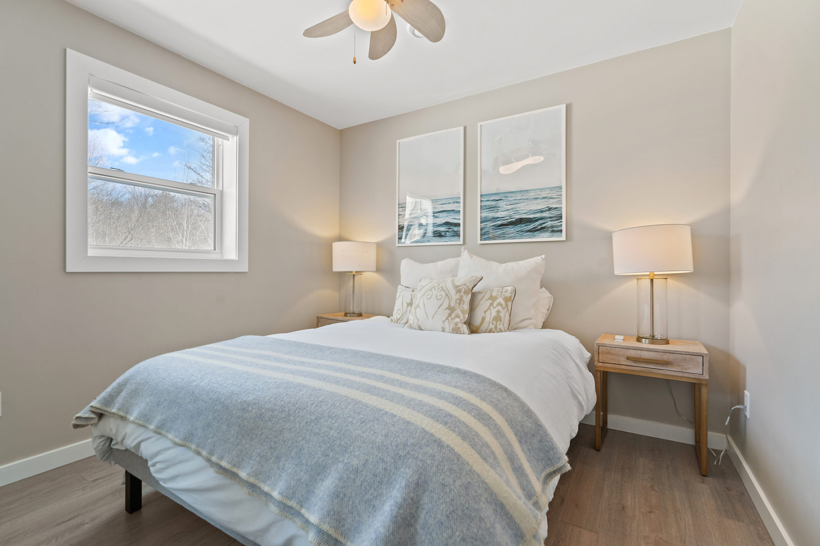 A bright bedroom with a nice-sized bed and a bedside table.