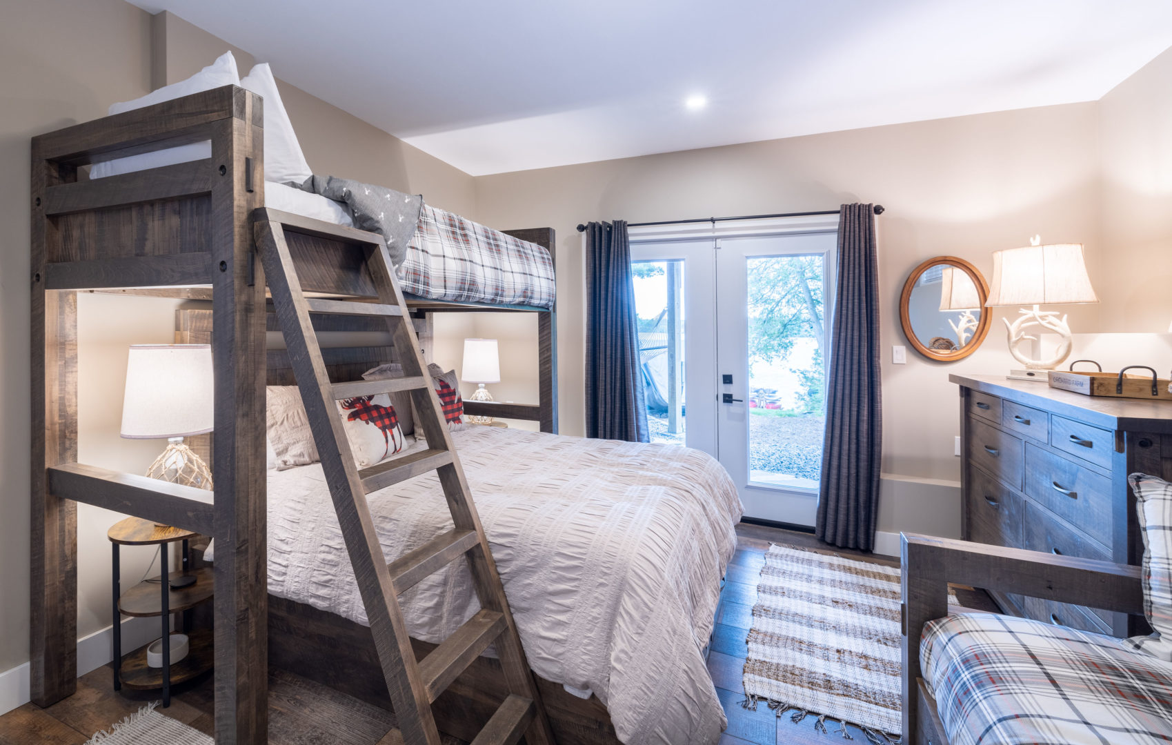 A bright bedroom with spacious bunk beds and walkout access to the outdoors.