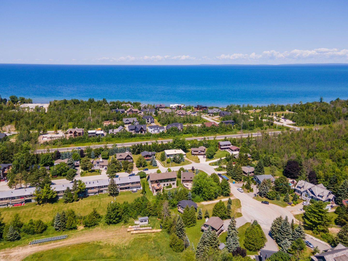 A residential area with a beautiful landscape, surrounded by trees and close to the water.