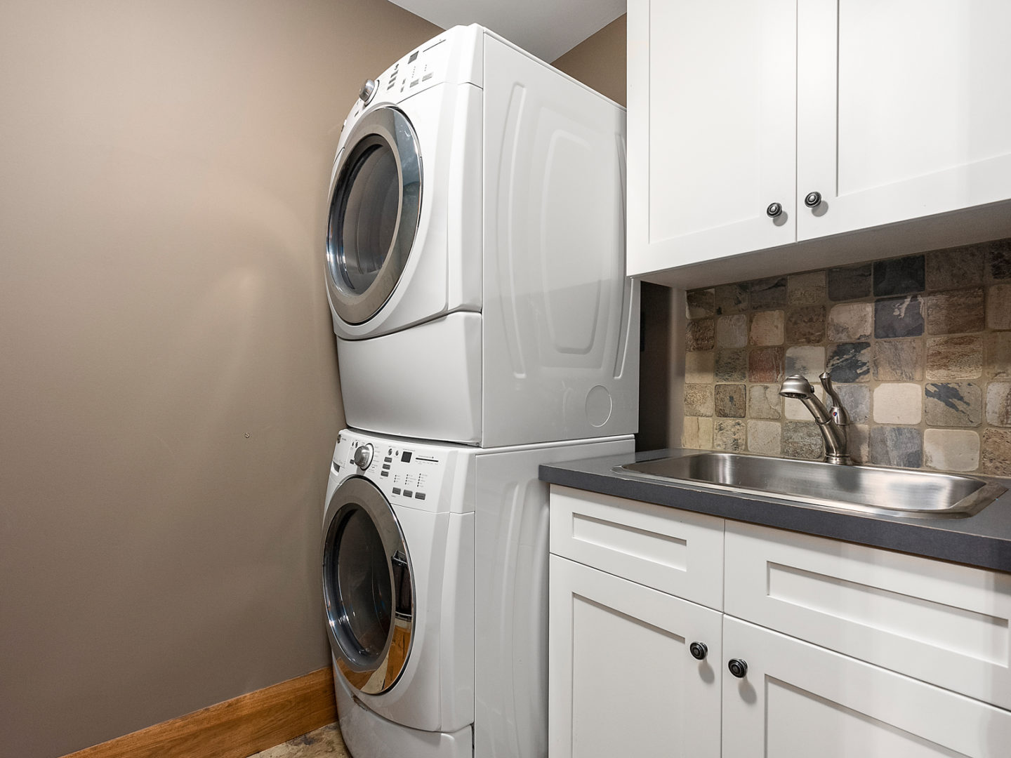 A small laundry area with a washer and dryer stacked on top of one another.