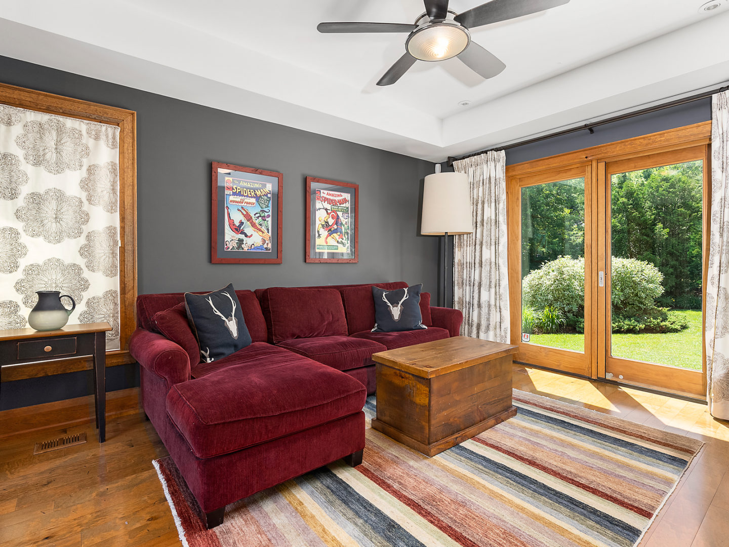 A big room with a couch and a double-door walk-out to a backyard.