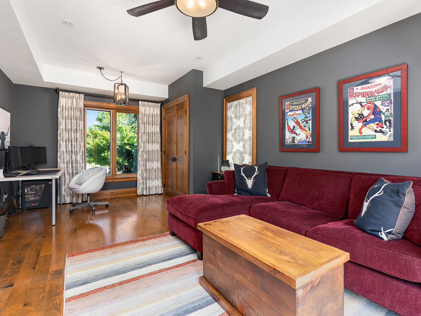 A big room with a couch, a desk, and a large window.