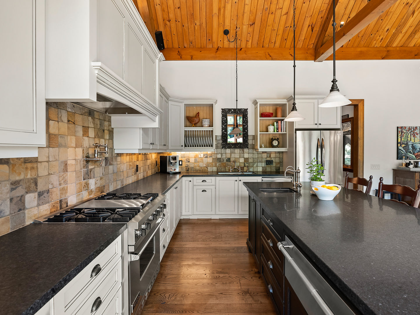 A big kitchen area with an island and modern appliances.
