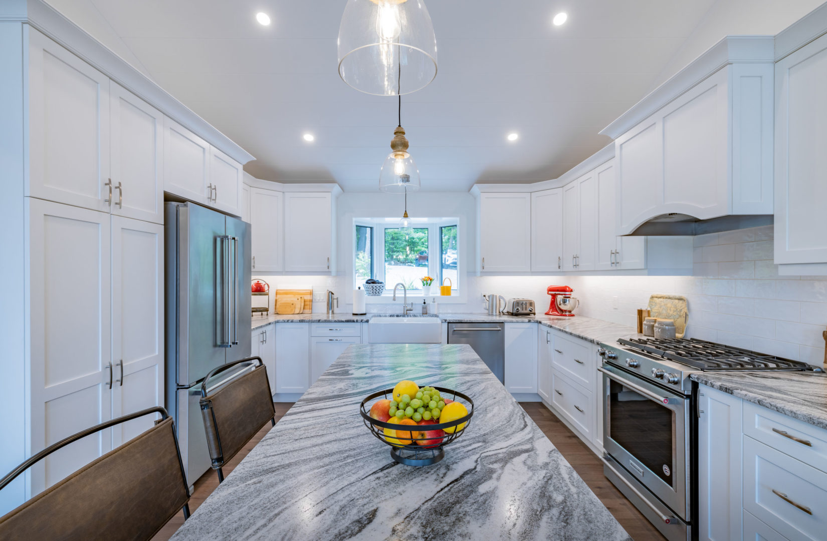 A modern kitchen with an island, white cabinets, and updated appliances.