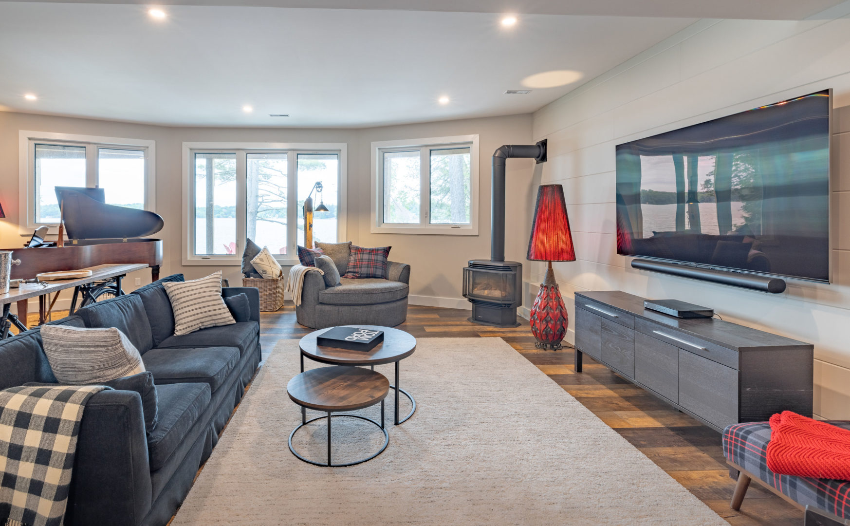 A bright basement living area with a couch, a chair, a coffee table, and a television.