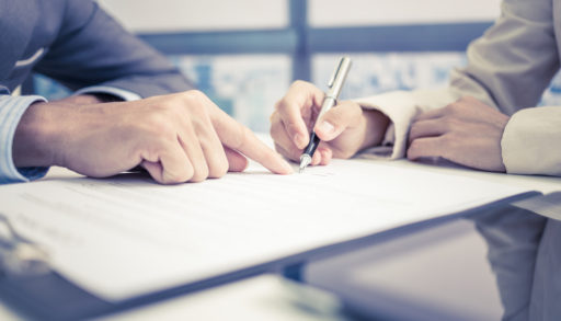 A female hand signing a liability contract