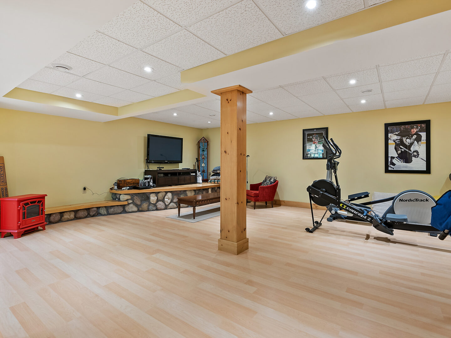 A spacious basement area with exercise equipment and a television.