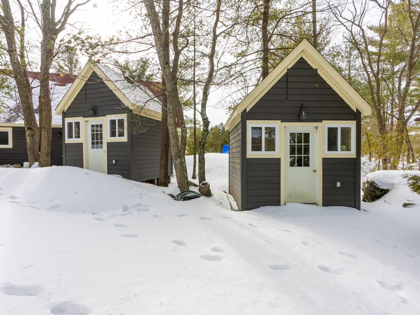 Two small bunkies side by side, both with navy exteriors and white doors.