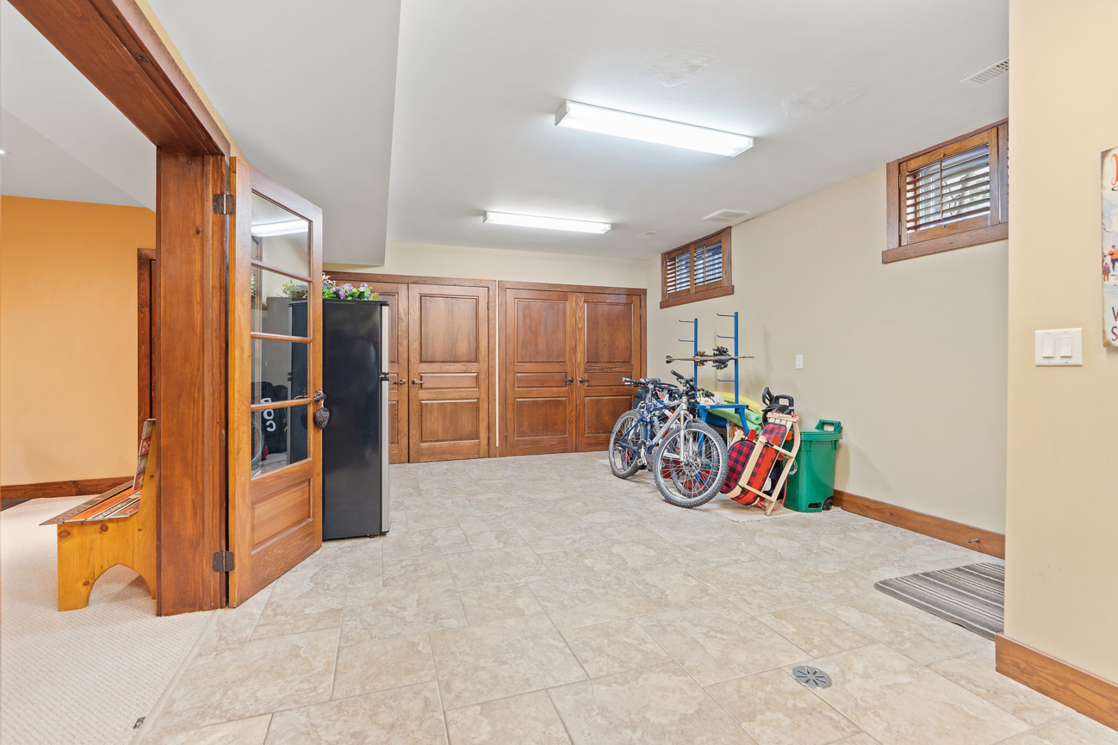 A spacious basement area with a fridge and storage.