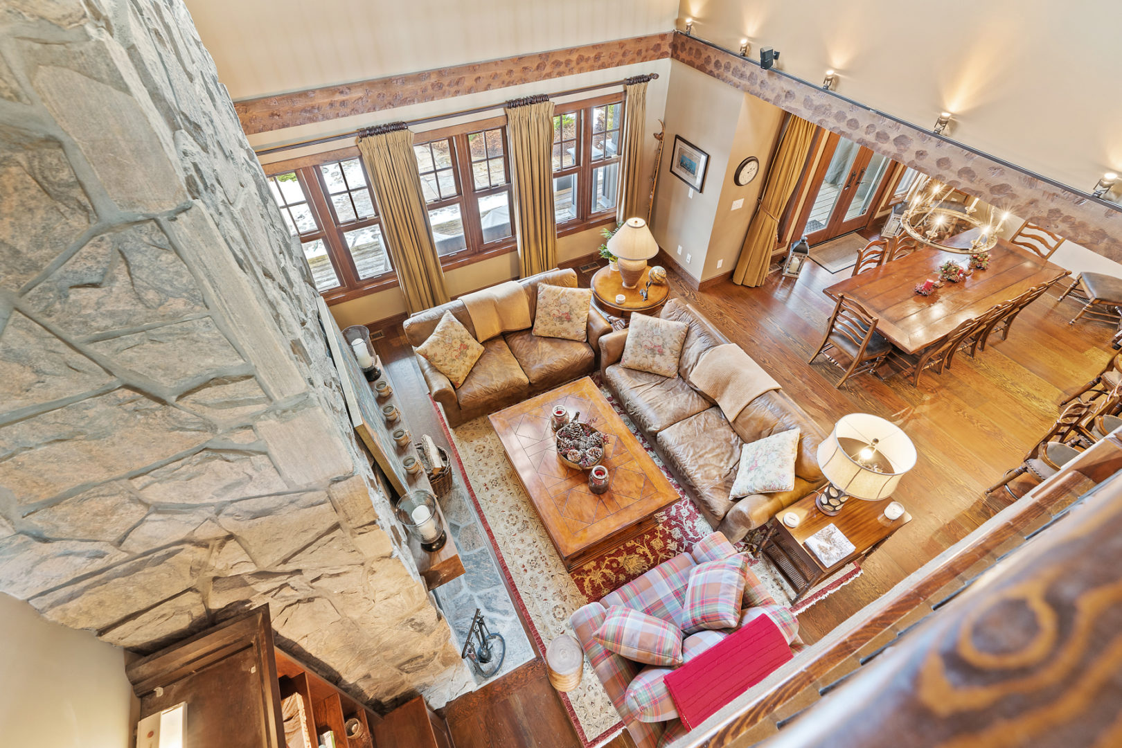 Overhead view of a bright open-concept living space with couches, chairs, and a floor-to-ceiling fireplace.