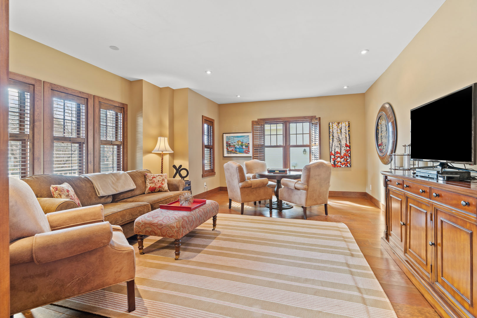 A spacious family room with a couch, a small table and chairs, and a television.