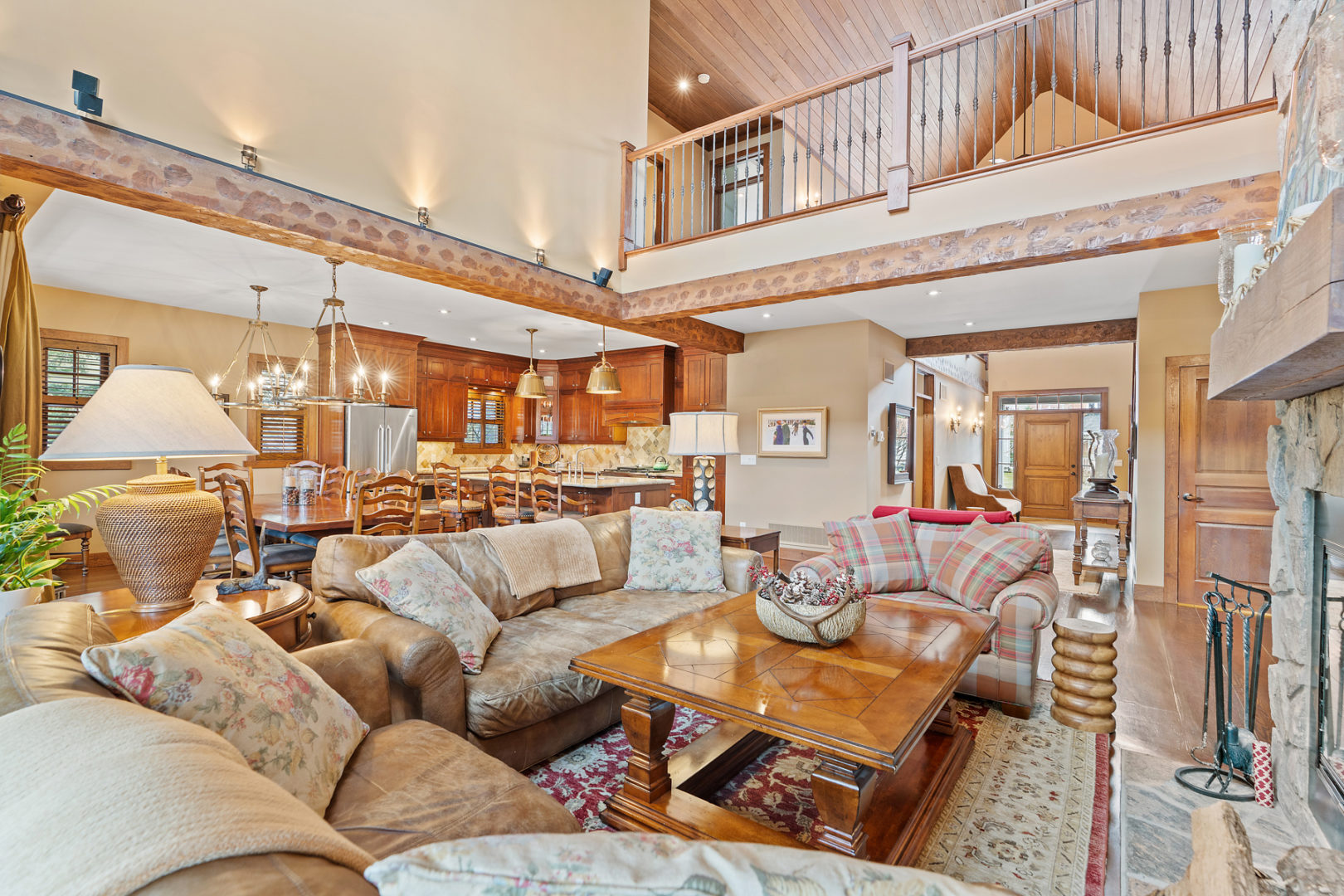 An open-concept chalet living area. The second floor is open with a balcony above.