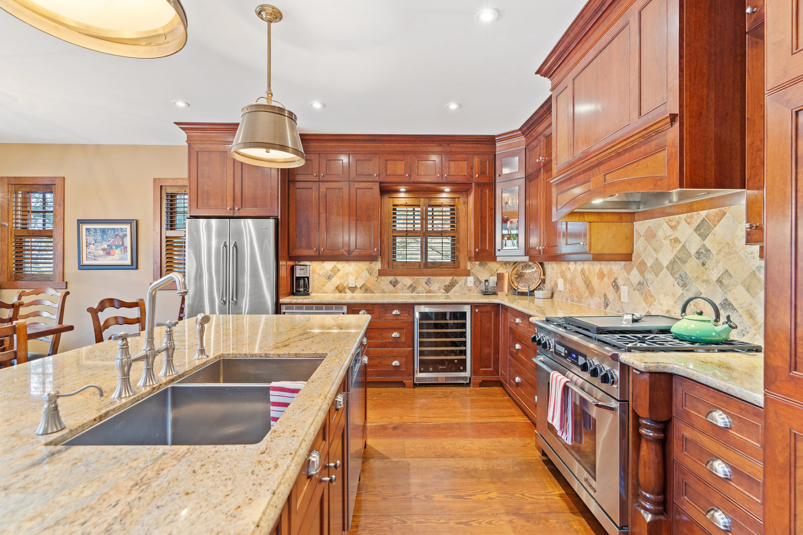 A large kitchen with warm wood cupboards, an island, and modern appliances.