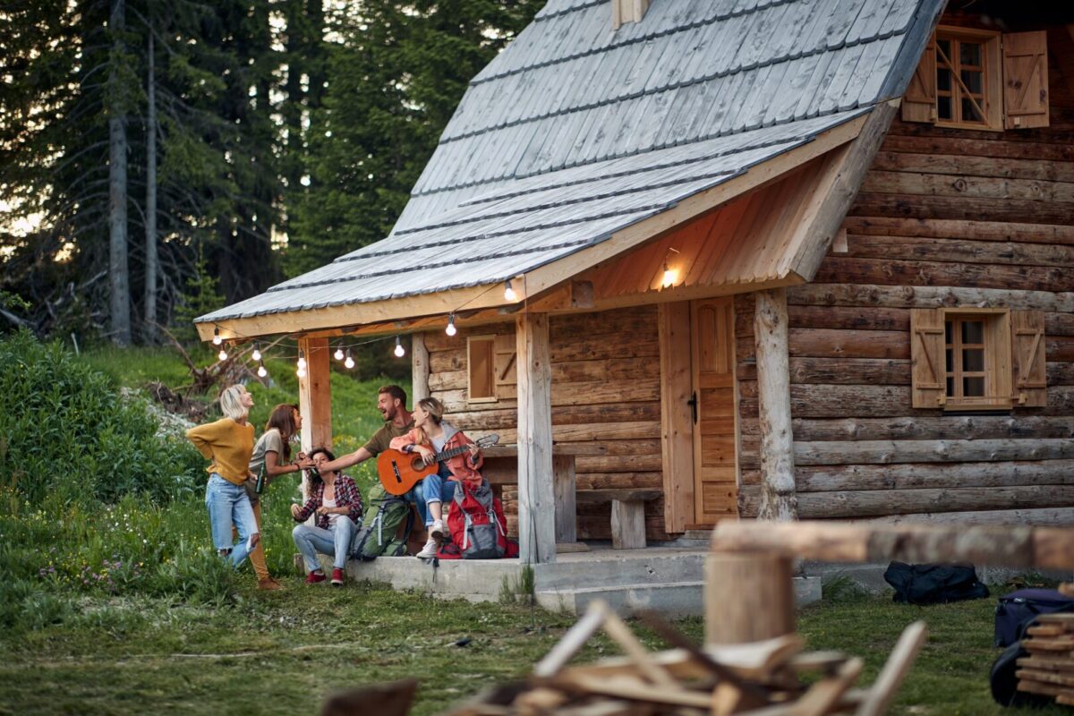 a group of friends on the porch of a cottage