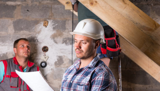 Three men in the middle of finishing a basement