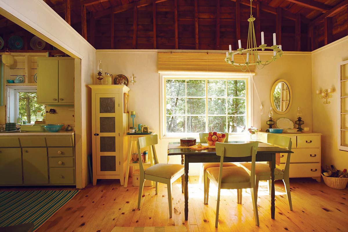 Minimalist chairs around a table in a sunny cottage kitchen