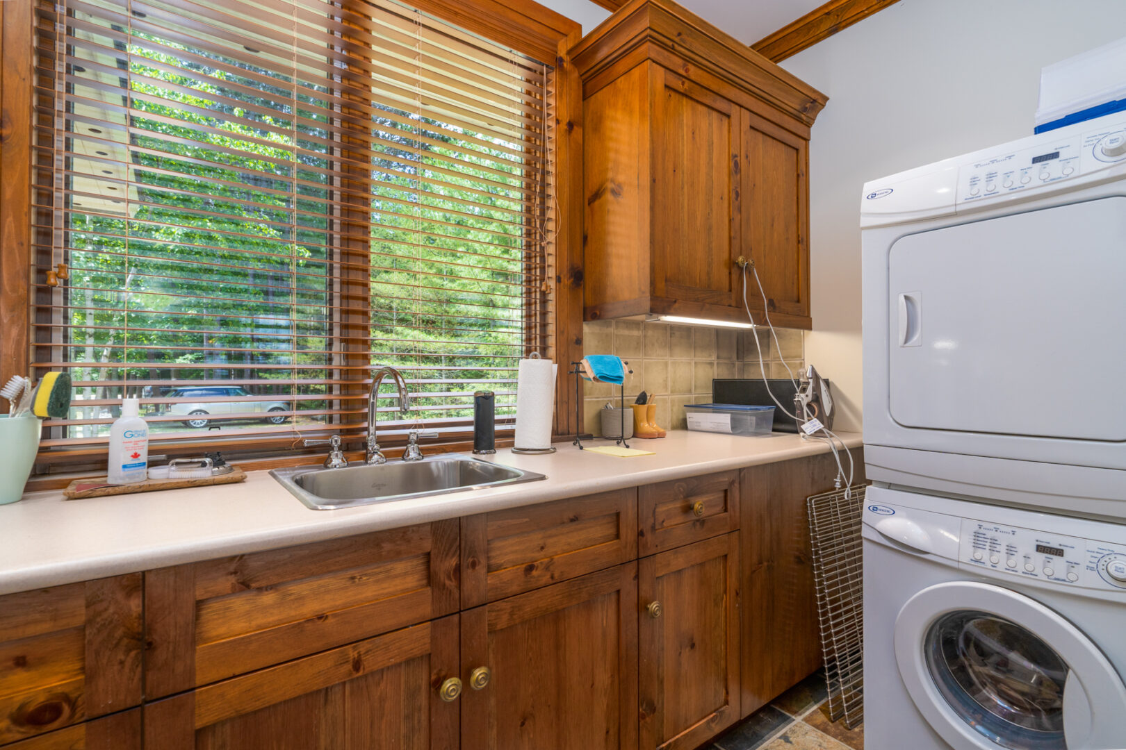 A small space with a sink, a washing machine, and a dryer.