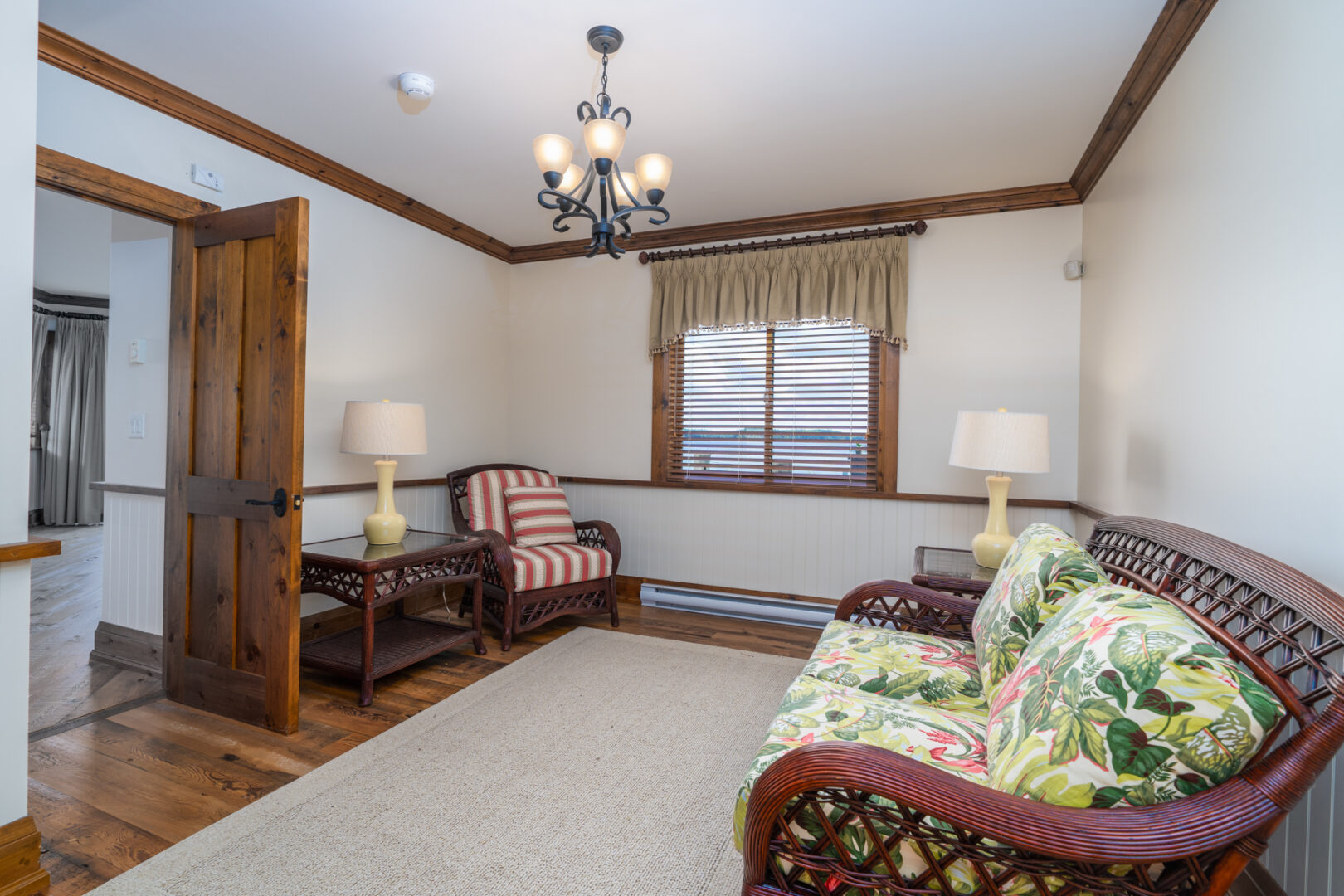 A small sitting area in a boathouse, with a couch, a chair, and a rug.