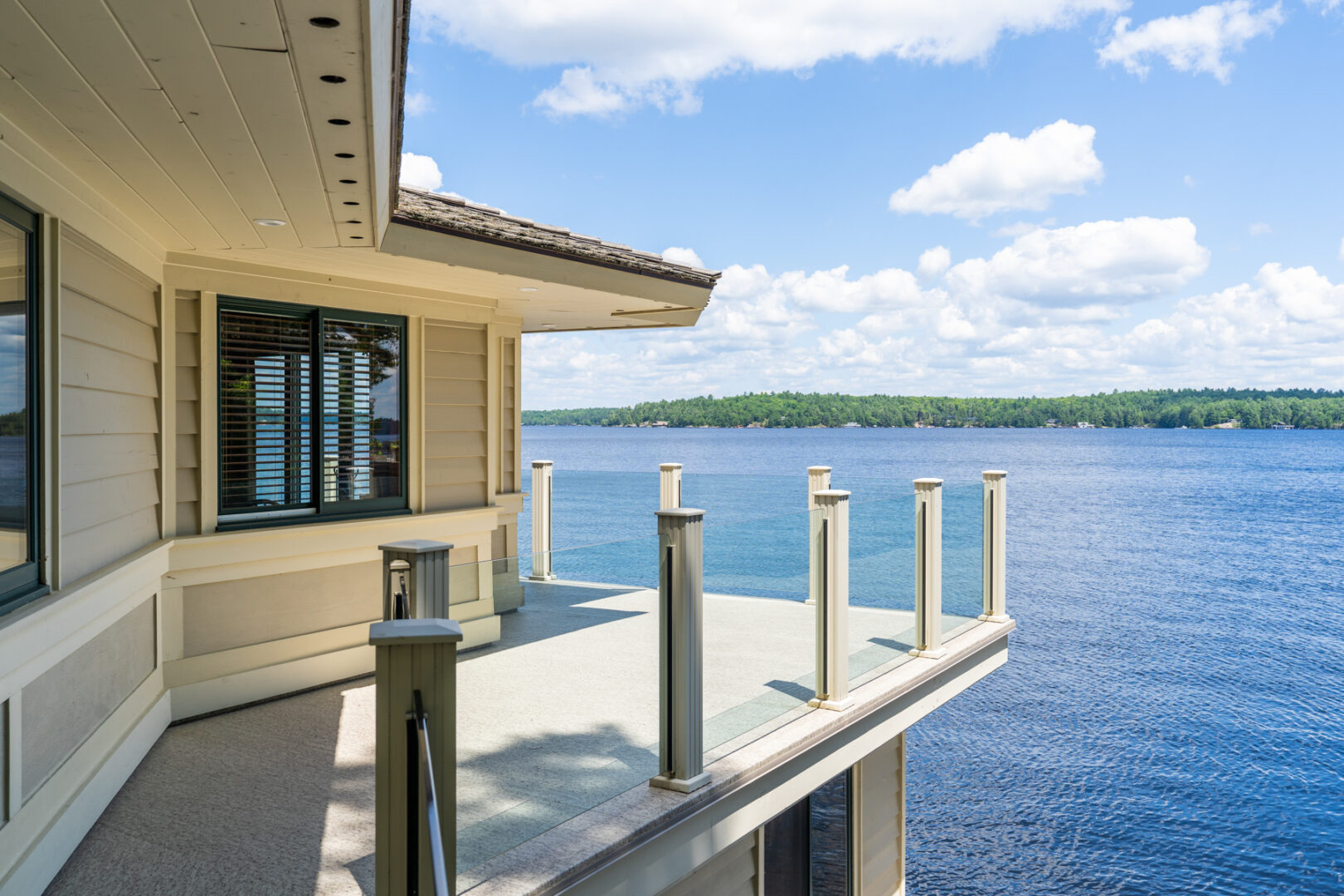 A balcony deck area on a large boathouse, looking out over a blue lake.