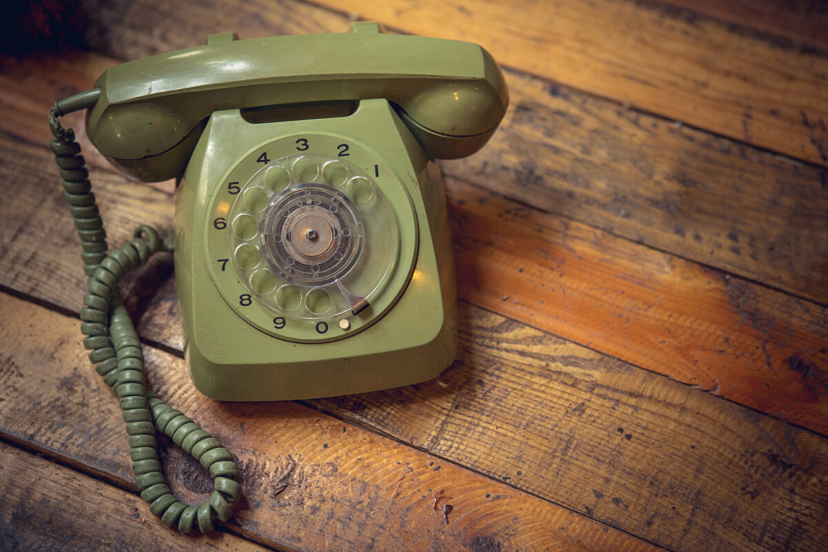 Vintage old rotary telephone with 10 digits on wooden table background