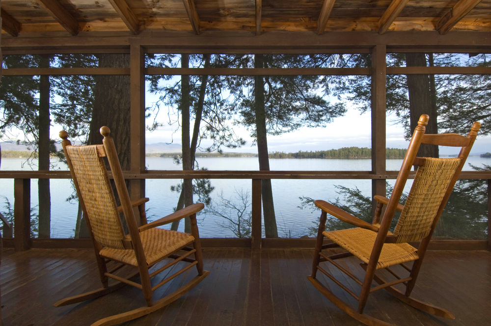 Rocking chairs on a porch looking out over a lake at the cottage