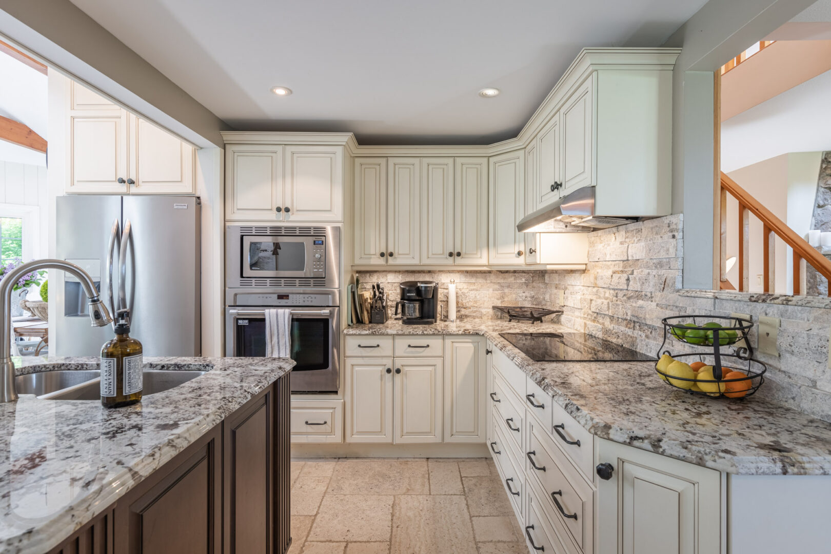 A large kitchen area with cream-coloured cabinetry and a big island.