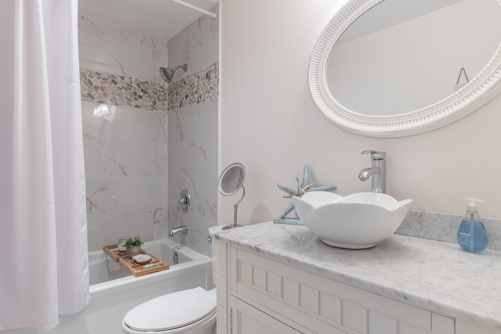 A small, white bathroom with a shower/tub combo, a toilet, and a sink.