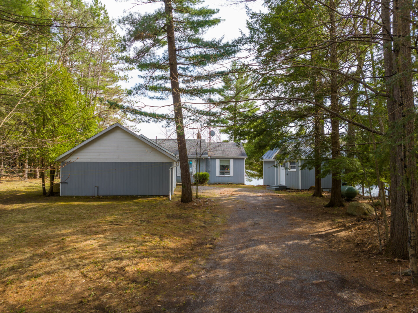 A long driveway leads to a small cottage and a bunkie.
