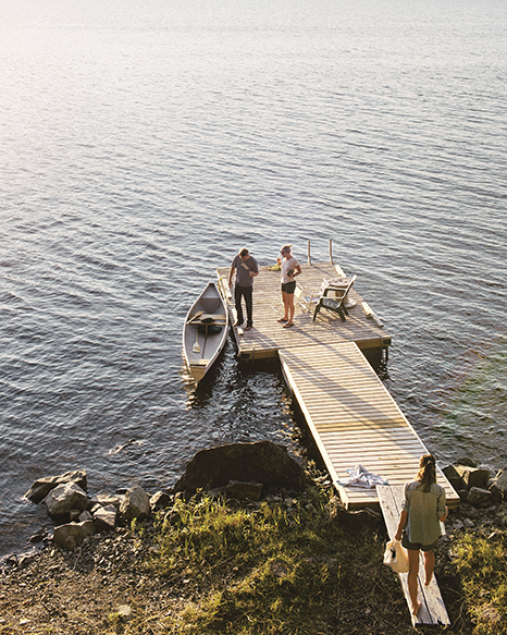 extended family stands on dock beside canoe