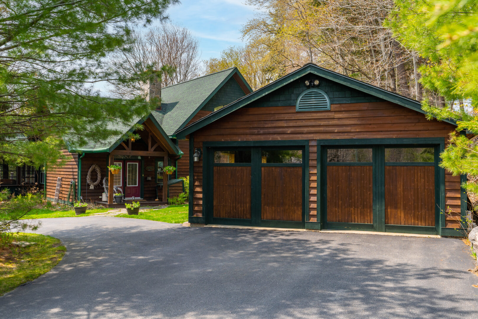 A big two-car garage with dark wood exterior and green accents.
