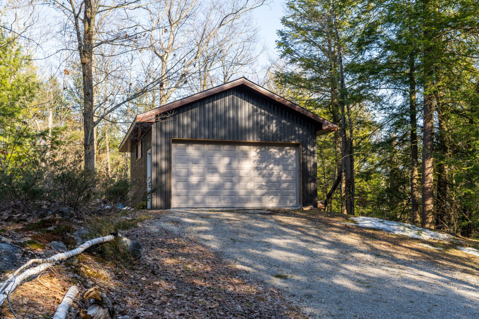 Exterior of a detached two-car garage with white doors.