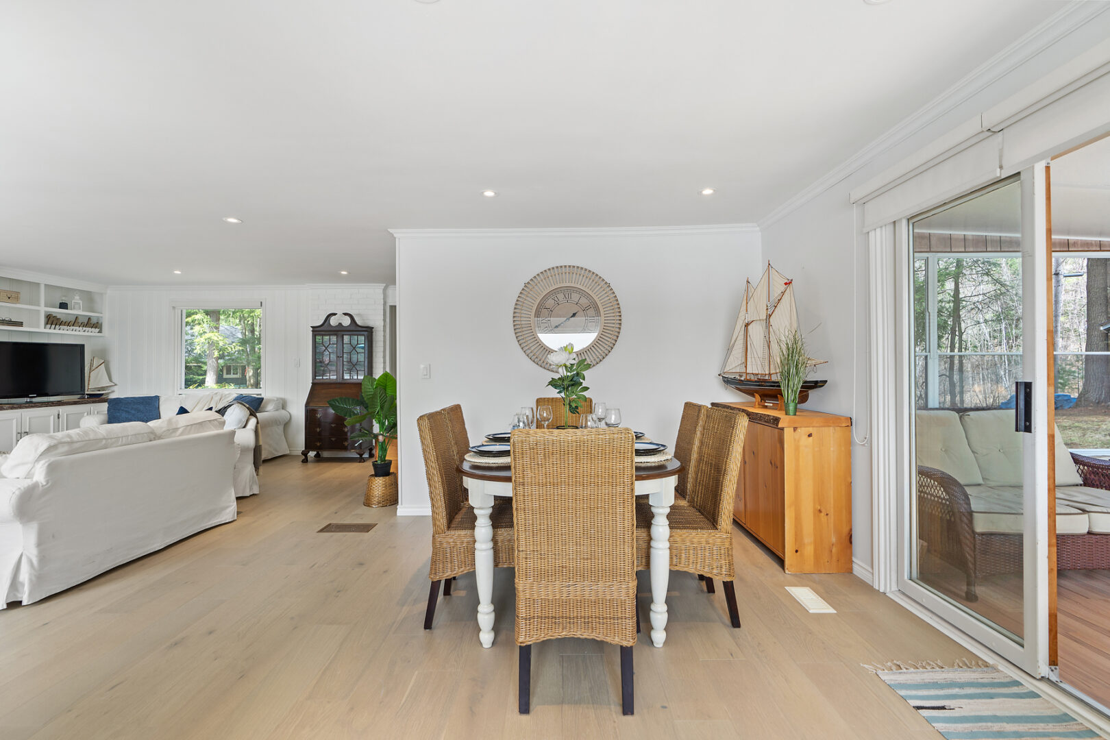 An open-concept living space with a dining table and chairs and a living space off to the side.