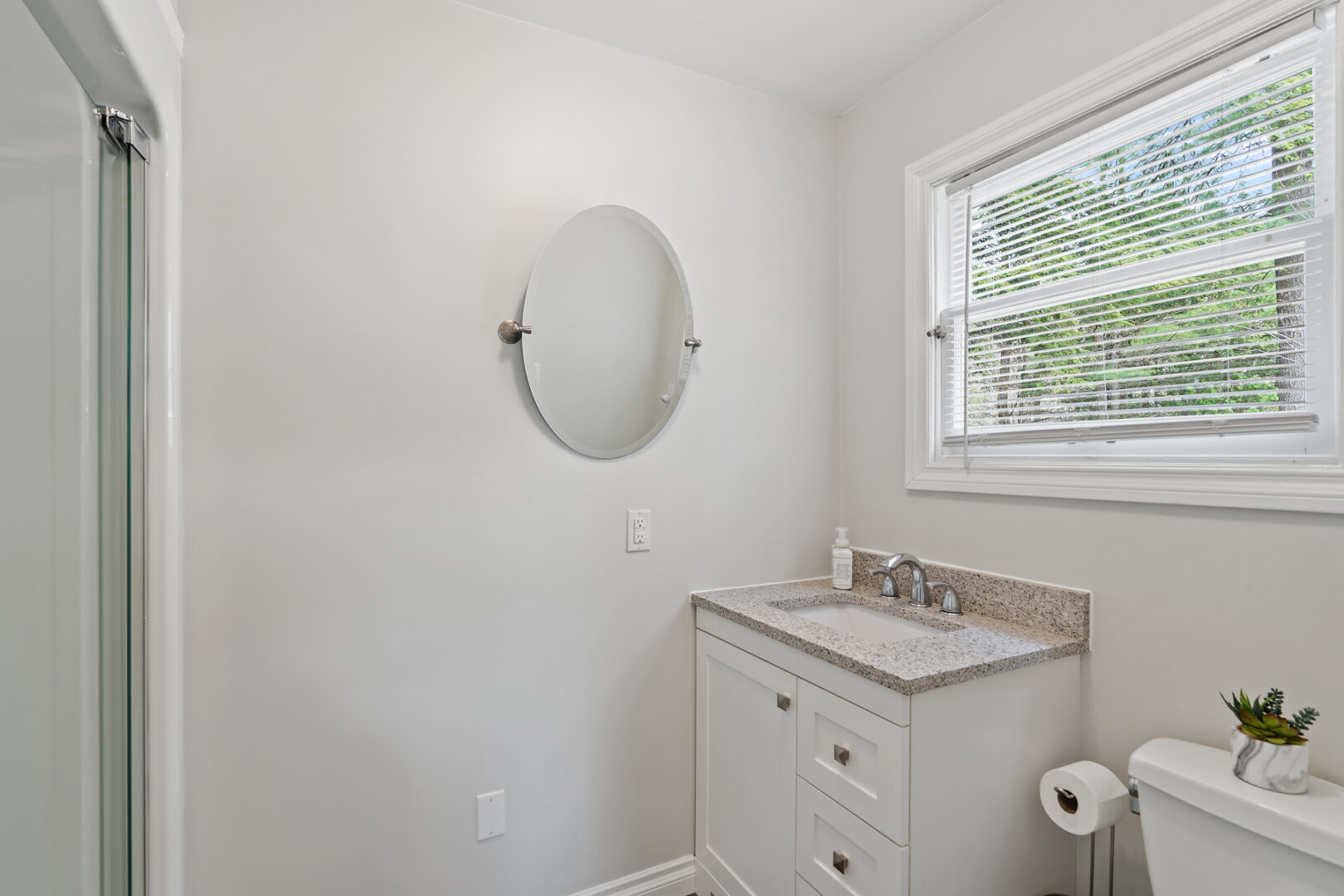 A simple bathroom with a toilet, a sink, and a shower.