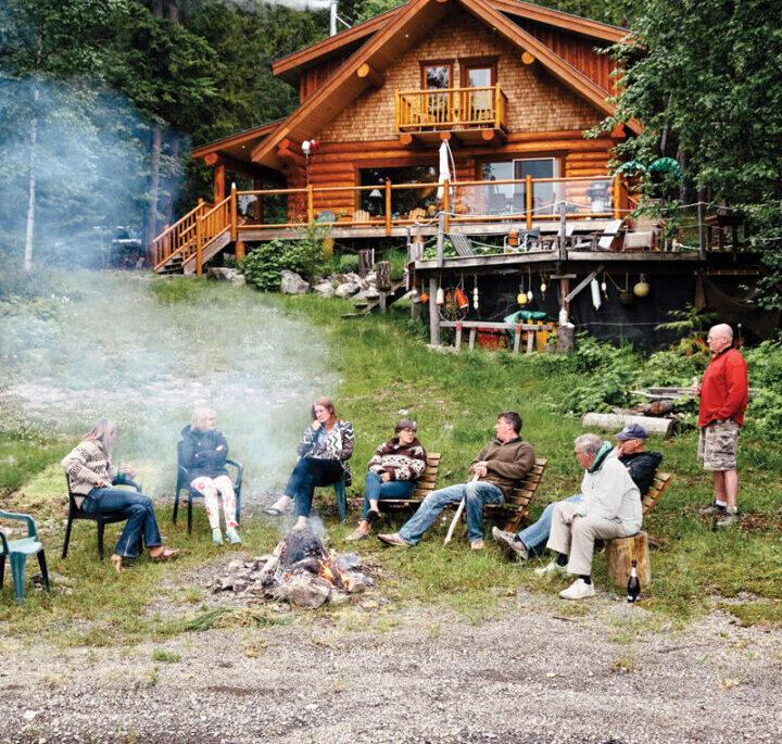 Gunn family sits around the fire in front of their cottage