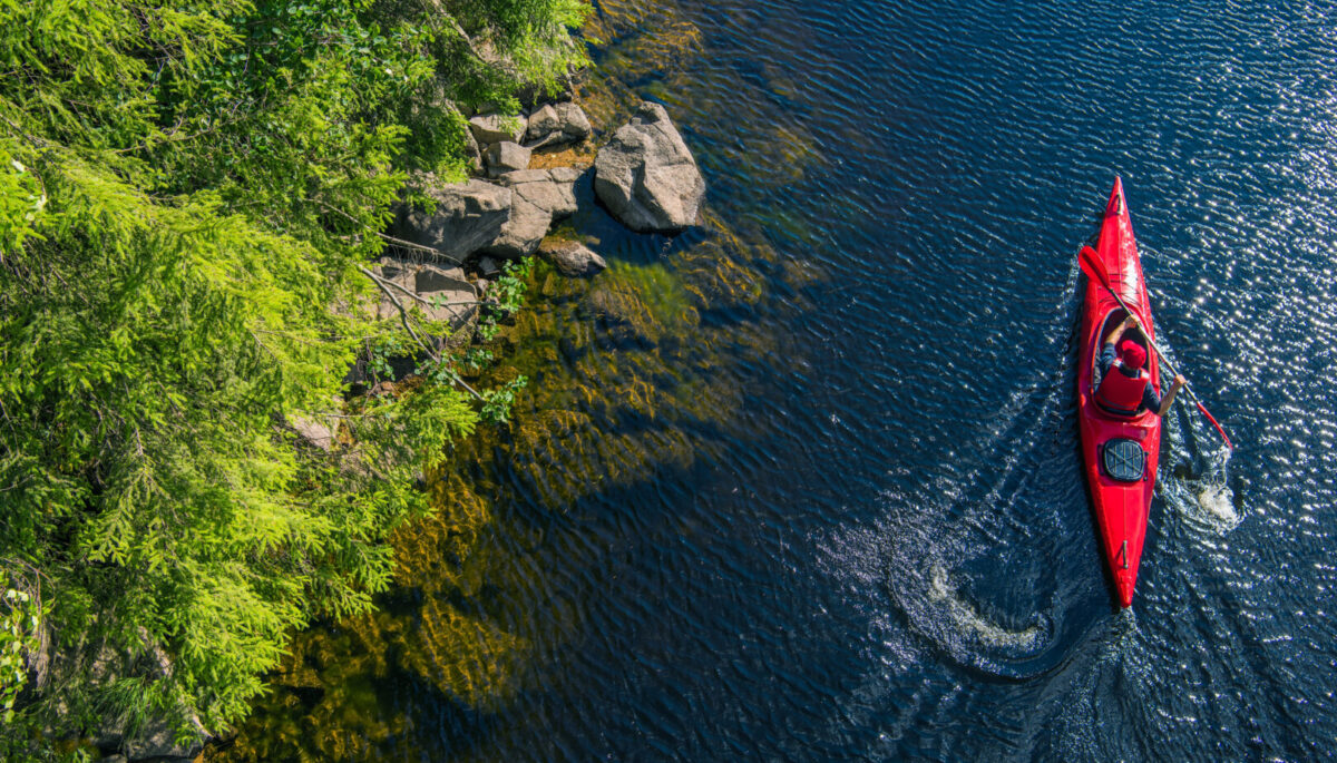 aerial view of a red kayak along a rocky shorelines