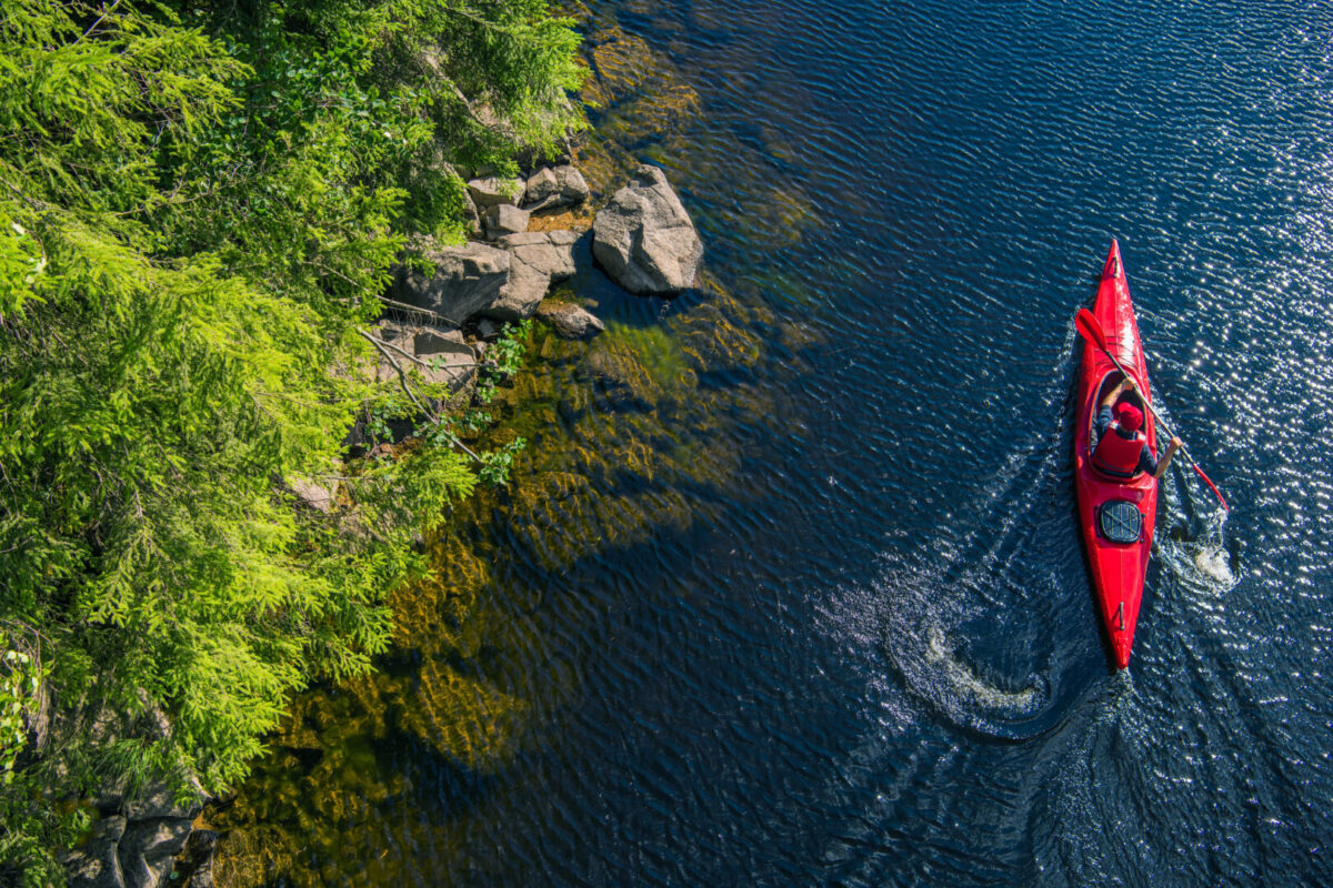 aerial view of a red kayak along a rocky shorelines